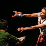 Photo of Bamboozle's AS production Moon Song. An actor introduces her rocket flying through space to a member of the audience.
